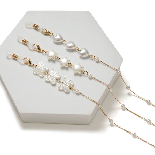 Gold-toned chain necklace featuring white pearls and silver star and butterfly charms