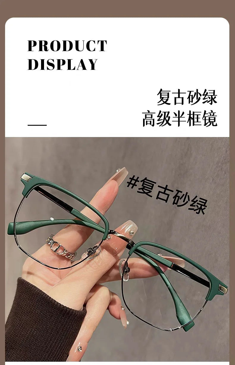 Eine Hand hält eine grüne Anti-Blaulicht-Lesebrille mit silbernen Akzenten vor einem neutralen Hintergrund.