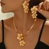 Gold floral pendant necklace and matching earrings worn by a woman