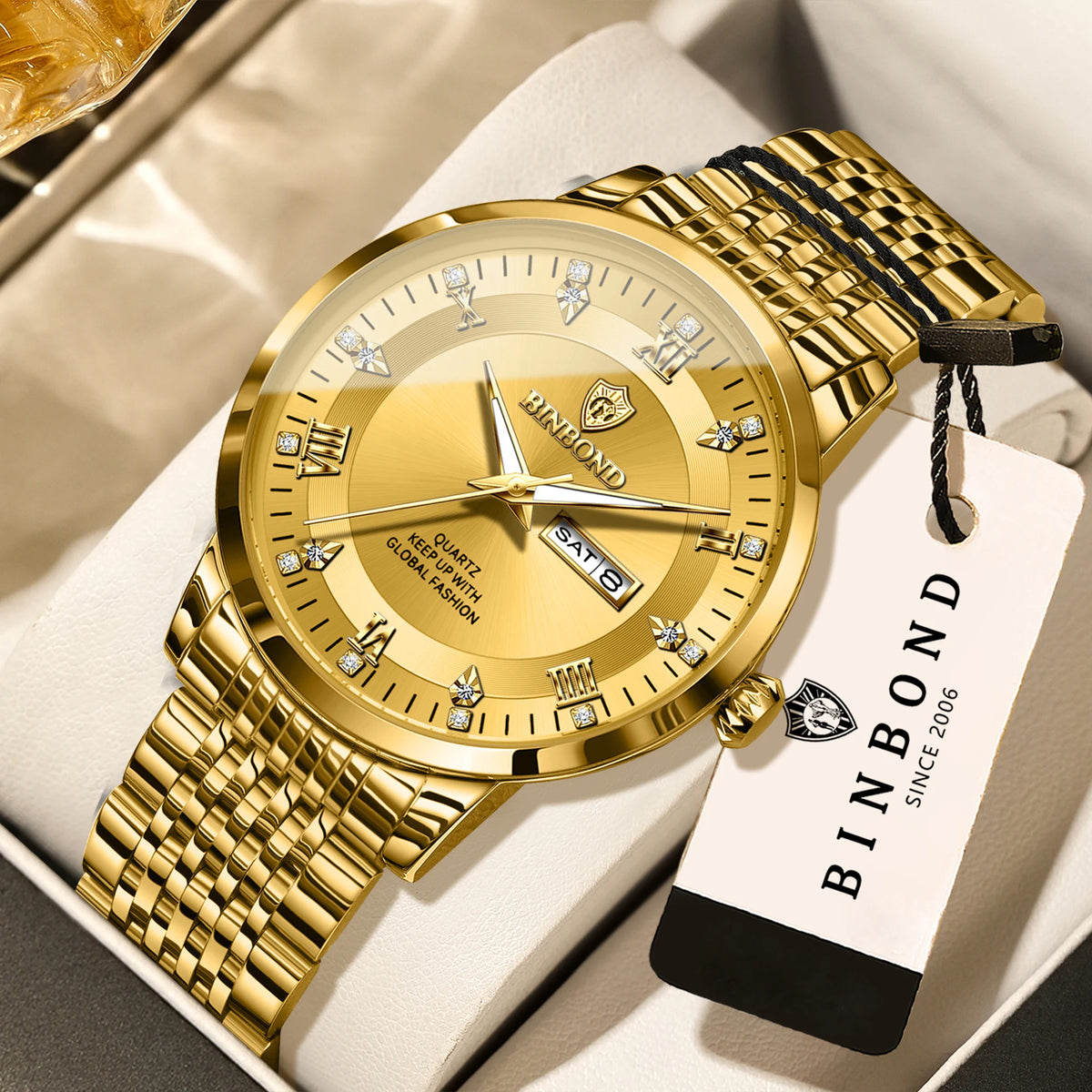 A gold-toned Bindond wristwatch with a leather strap and a white box background.