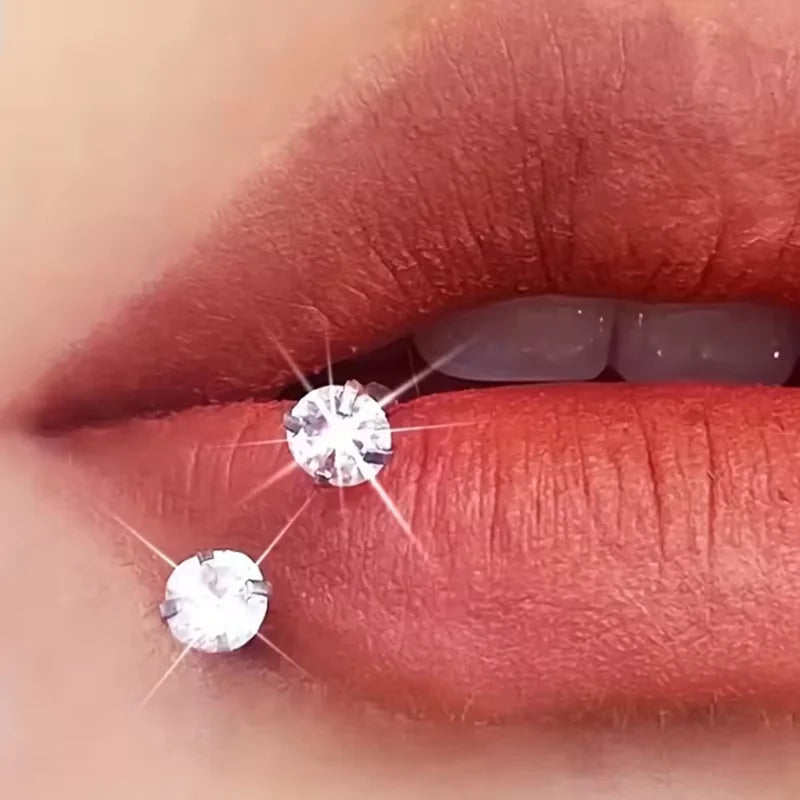 Close-up of a person's lips showing two sparkling silver horseshoe nose rings.