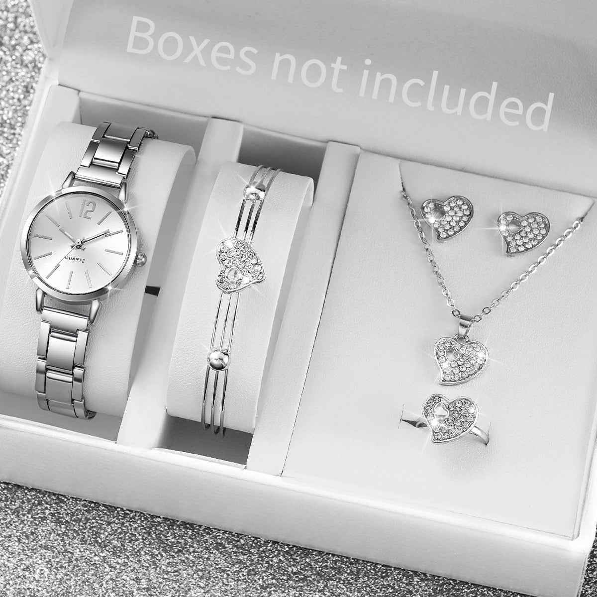 A white box contains an elegant quartz wrist watch, a silver bracelet, and a necklace with heart-shaped pendants.