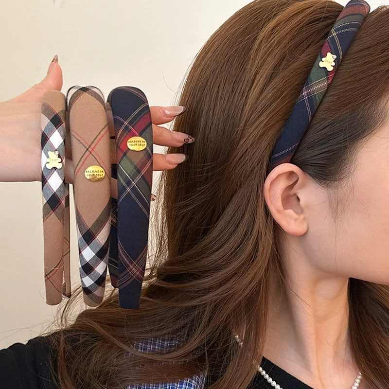 A woman is shown wearing a British plaid sponge headband on her hair.