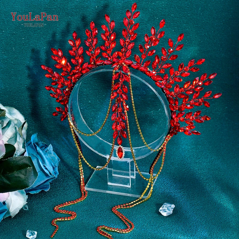 A vibrant red rhinestone bridal crown headband with gold chains and foliage displayed on a dark teal background.
