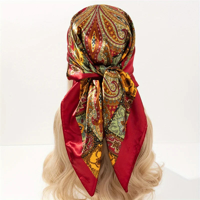 A red satin silk scarf with an ornate paisley pattern tied around a blonde wig.