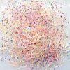 A pile of colorful disposable hair scrunchies in various shades of pink, purple, and clear.