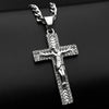 A silver-tone stainless steel cross pendant necklace with rhinestone accents displayed against a black background.