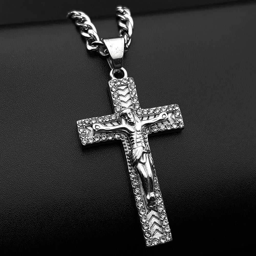 A silver-tone stainless steel cross pendant necklace with rhinestone accents displayed against a black background.