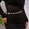 A woman wearing a silver heart waist chain body jewelry on a black dress.