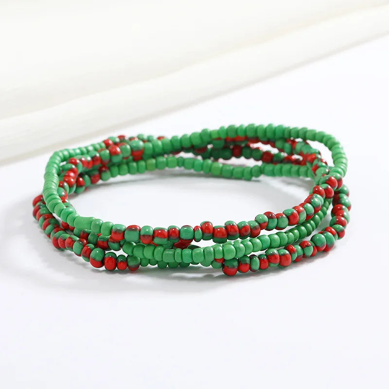 Una pulsera hecha de pequeñas cuentas rojas y verdes, apiladas en varias hebras.