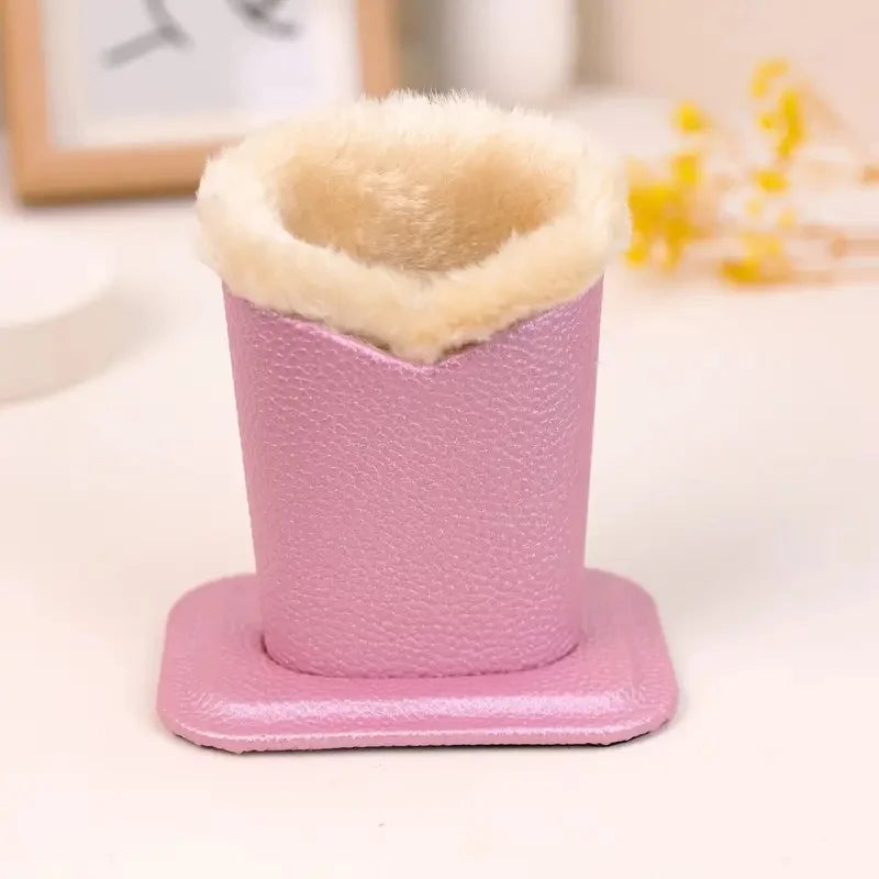 Rosa Plüsch-Brillenhalter mit beigem flauschigem oberen Teil auf weißer Fläche.