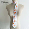 A white long neck tie featuring an orange goldfish print displayed on a mannequin.