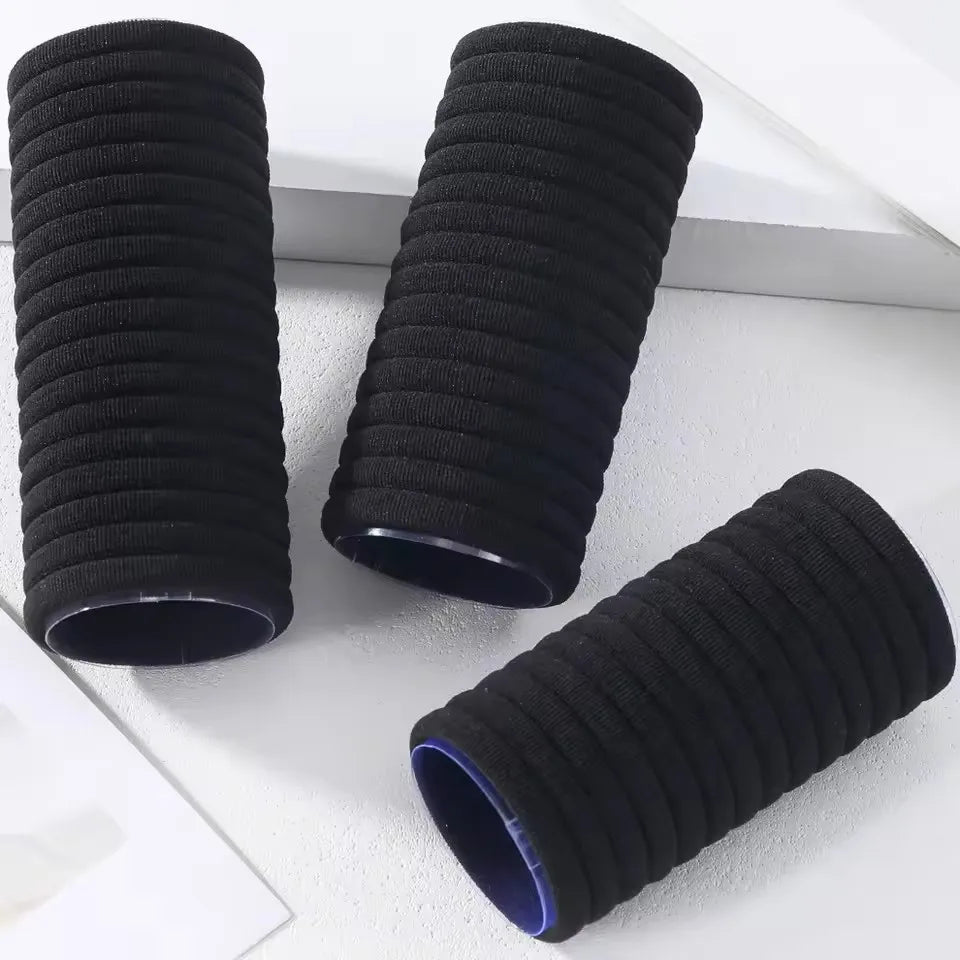 Three black elastic hair ties for ponytails and buns shown in a vertical arrangement.