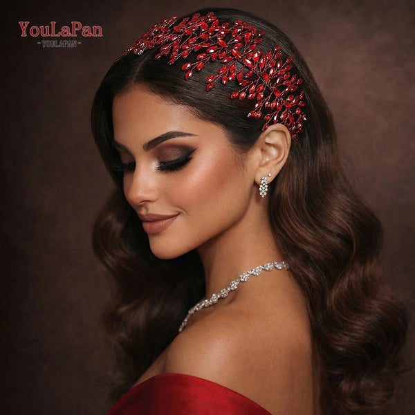 A close-up portrait of a woman wearing a red rhinestone bridal headband and diamond earrings.