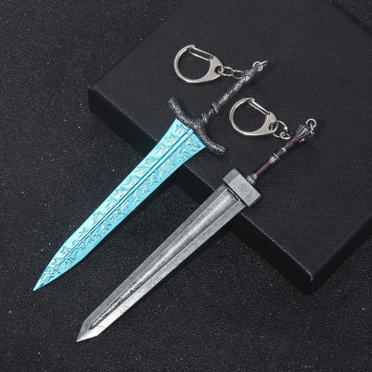 A silver dagger with a blue iridescent blade and hilt, attached to a keyring.
