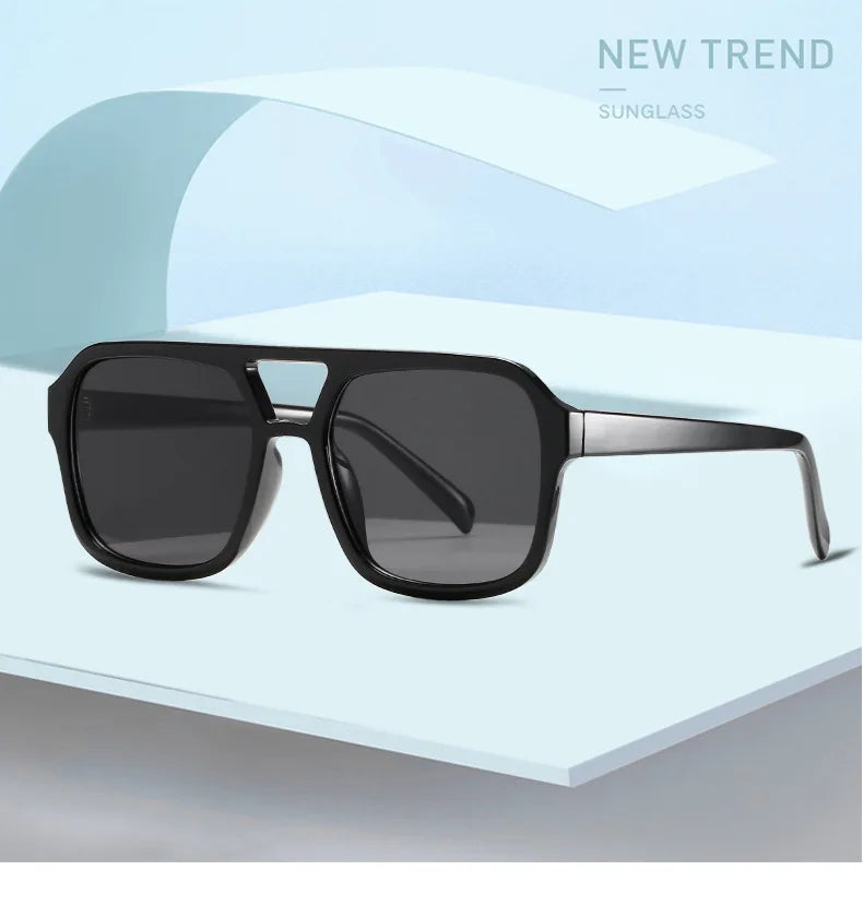 Schwarze Vintage-Pilot-Sonnenbrille mit doppelter Brücke auf einer hellen Oberfläche.