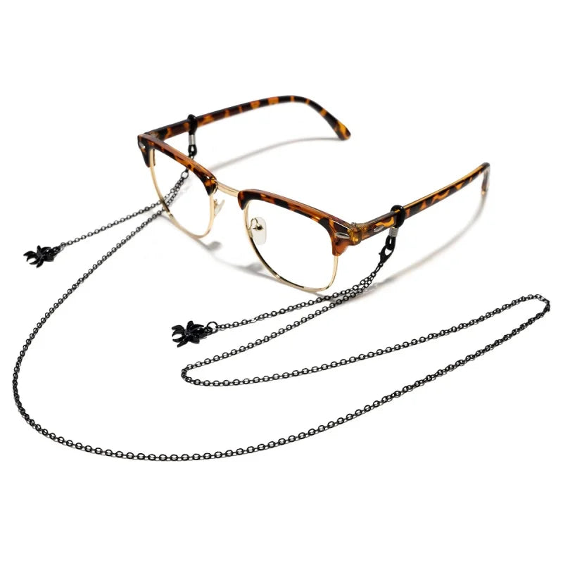 A pair of tortoiseshell-patterned glasses with a thin metal frame and a delicate chain necklace.