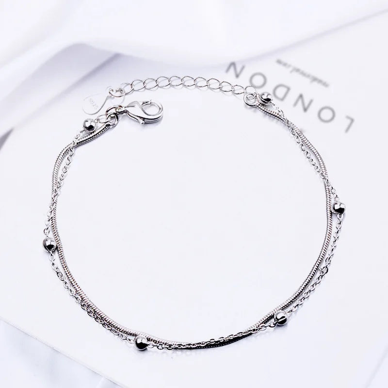 Sterling silver double heart charm bracelet displayed on a white background.