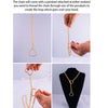 A close-up of a gold slip chain necklace with a heart pendant being threaded onto the chain.