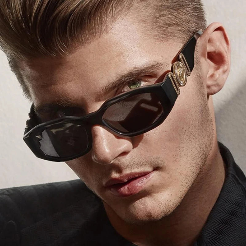 Nahaufnahme eines männlichen Models mit schwarzen Vintage-Sonnenbrillen mit Goldakzenten.