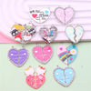 Un juego de collares de amistad en forma de corazón rosa y iridiscente con varios diseños lindos.