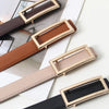 A close-up of a tan faux leather belt with a gold buckle and a light pink faux leather belt.