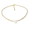 A delicate necklace made of mother of pearl beads with crystal accents and a gold-colored cord.