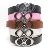 A stack of vintage gothic moon star buckle belts in black, pink, brown, white, and dark brown.