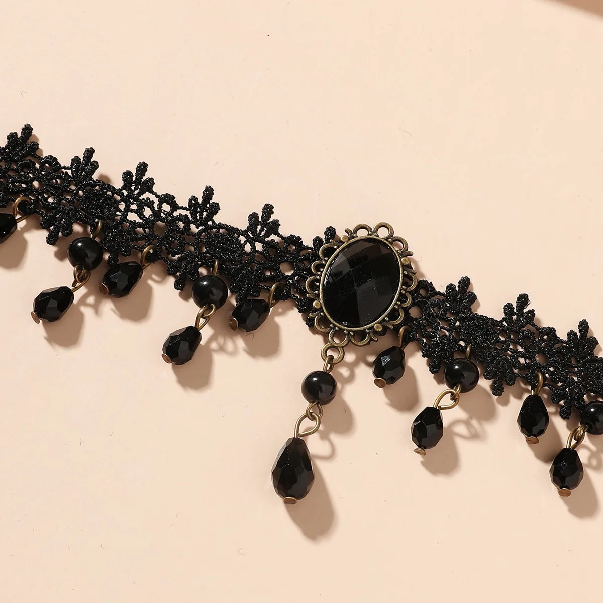 A black lace choker necklace featuring dark beads and a central black stone.