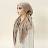 A model wearing a beige satin silk hijab headband cap and white clothing.