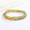 Una pulsera hecha de pequeñas cuentas redondas en tonos naranja y azul.