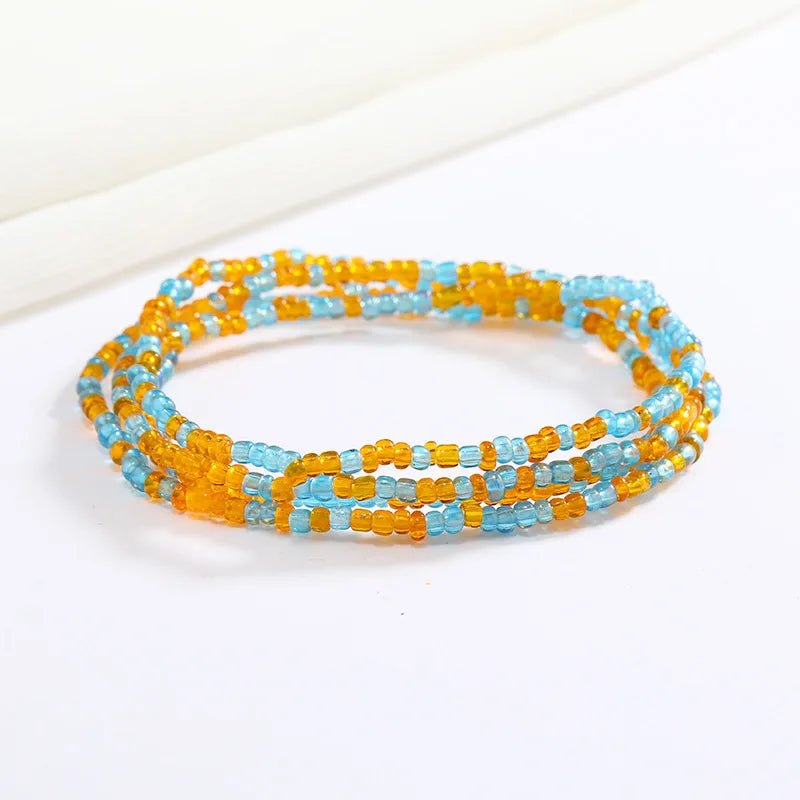 Una pulsera hecha de pequeñas cuentas redondas en tonos naranja y azul.