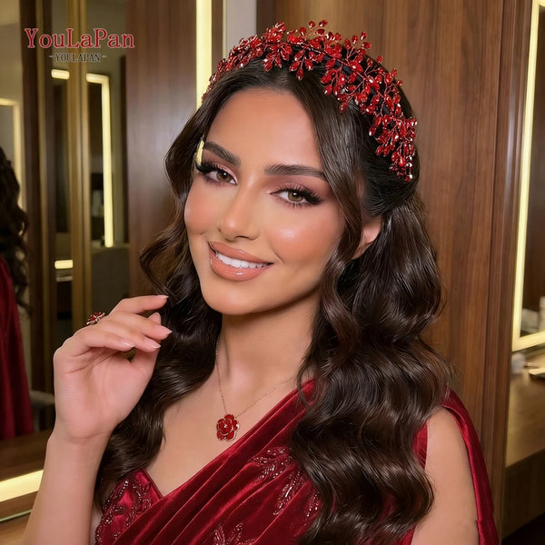 A woman models a red rhinestone bridal headband with long dark hair and a red velvet top.