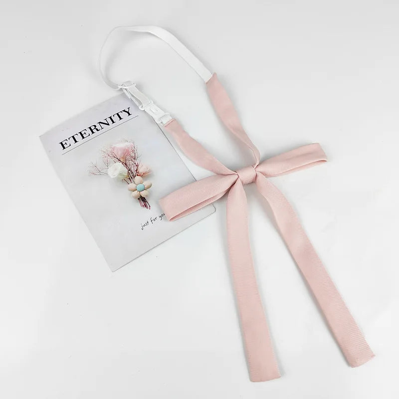 A pink ribbon tie set with a butterfly design is displayed on a white background.