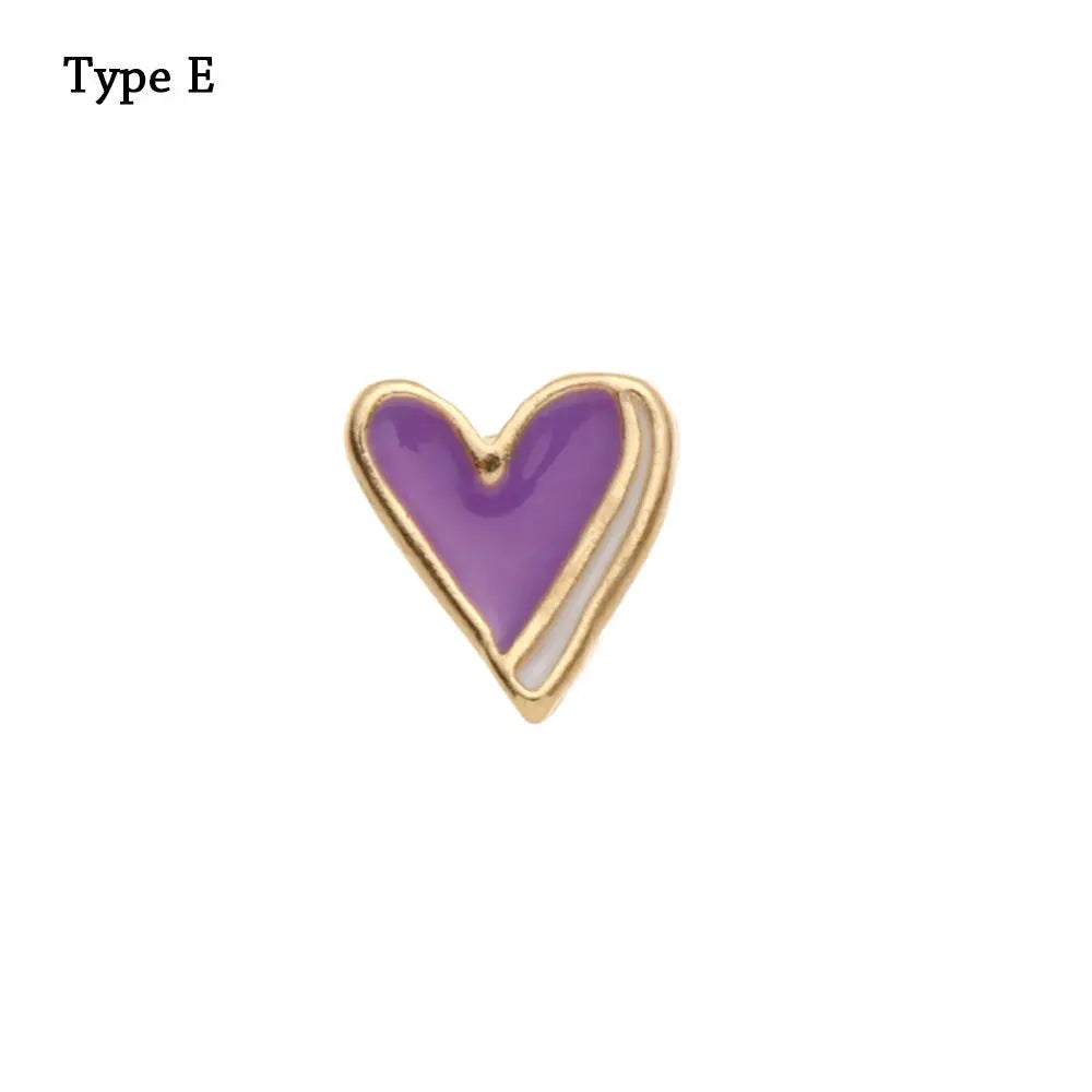 Adorno en forma de corazón con relleno de esmalte morado y borde metálico dorado.