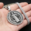 A vintage stainless steel pendant necklace featuring a Saint Benedict exorcism design on a silver chain.