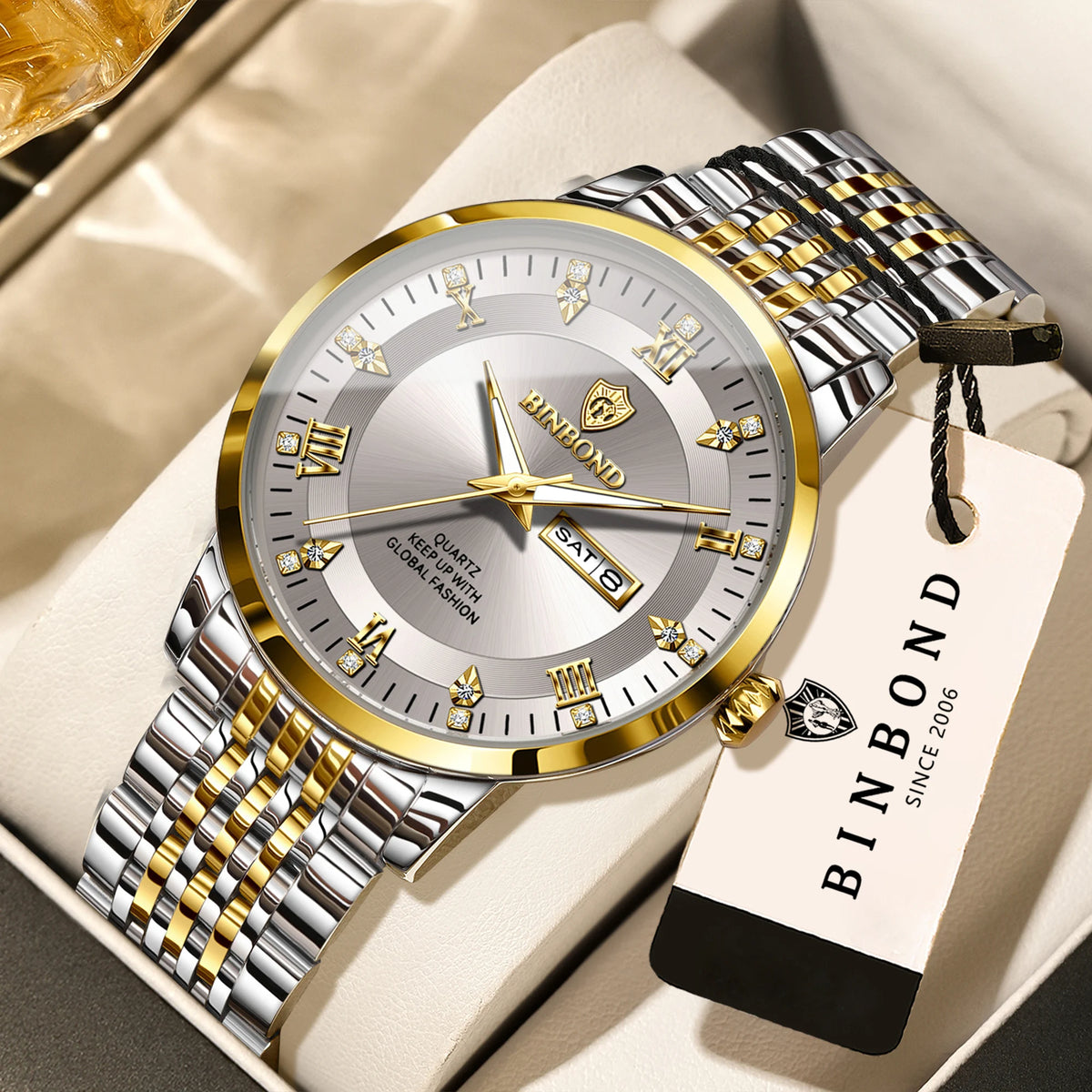 A gold and silver quartz wristwatch with a leather strap is displayed on a light background.