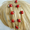 A set of ten red ladybug hair clips are displayed against blonde hair.