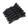 A set of six black alligator hair sectioning clips arranged in a fan shape.