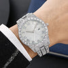 Raccourci de montre en diamant argenté porté sur un poignet, à côté d'une manche noire.