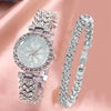 A silver rhinestone quartz watch and bracelet set displayed against a pink background.