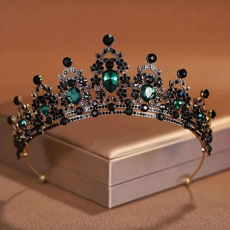 Diadema metálica oscura adornada con cristales y piedras verdes esmeralda y negras.