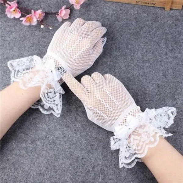 Pair of sheer lace fishnet evening gloves worn on a hand against a gray background.