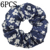 Seis diademas de satén con estampado floral azul marino que presenta flores y hojas blancas.