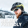 Ein Mann mit schwarzem Helm und Sonnenbrille ist im Schnee draußen zu sehen.