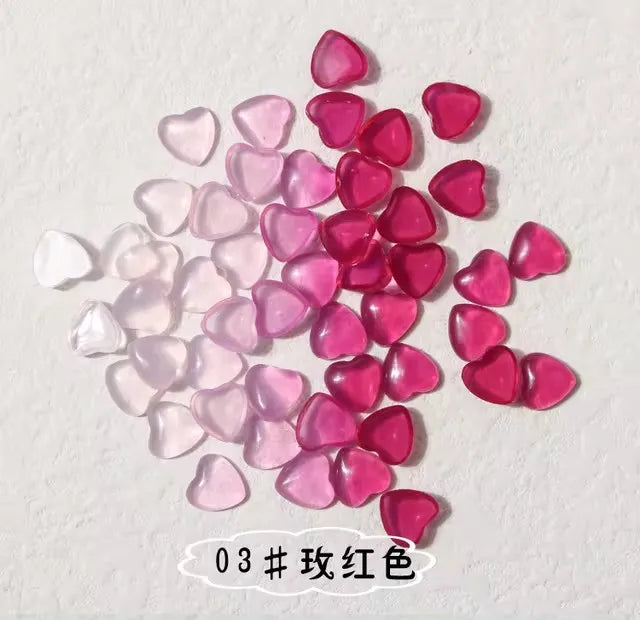 A collection of 10 pink and red resin heart-shaped nail art charms.