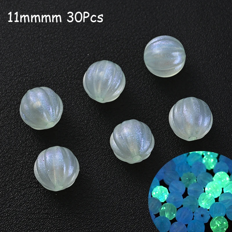 A collection of 30 clear glow-in-the-dark acrylic beads, measuring 11mm each, scattered on a dark surface.