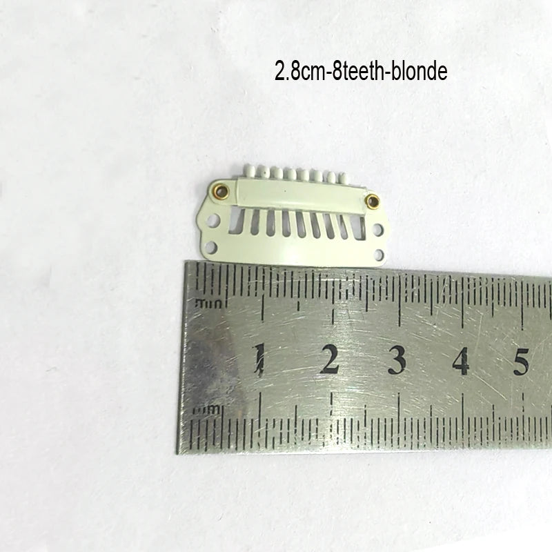 Une pince pour extensions de cheveux blanche avec huit dents est montrée à côté d'une règle pour l'échelle.