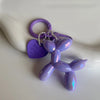 A purple jelly cartoon dog keychain with a purple heart tag and silver chain.