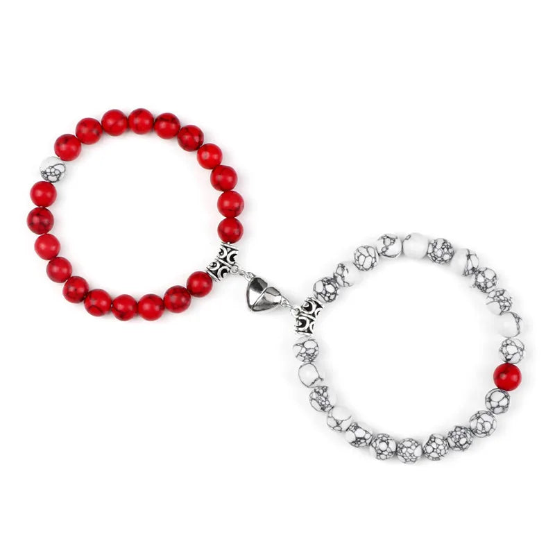 A pair of natural stone heart couple bracelets, one made of red beads and the other silver-toned.